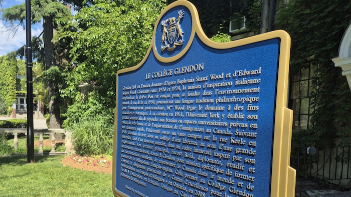 Une plaque en métal située tout près de la fenêtre de l'immeuble décrivant l'histoire du campus.