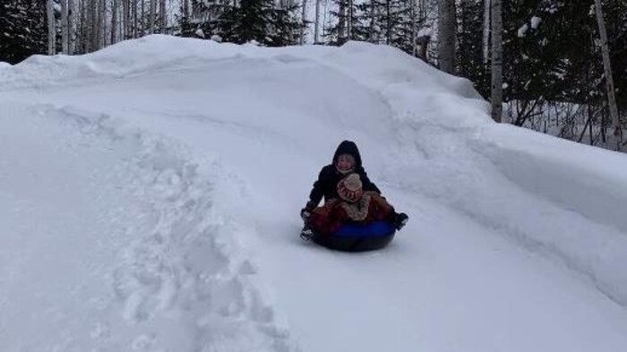 Une femme et un enfant glissent sur un tube.