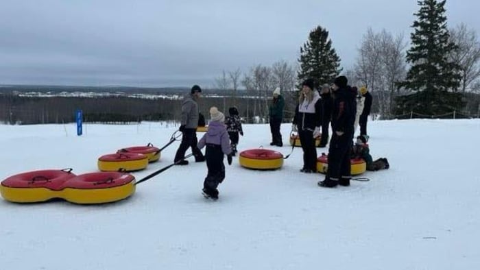 Des adultes et quelques enfants sont rassemblés autour 