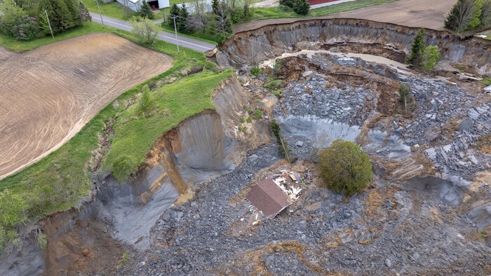 Une image aérienne d'une résidence dans un cratère de boue.