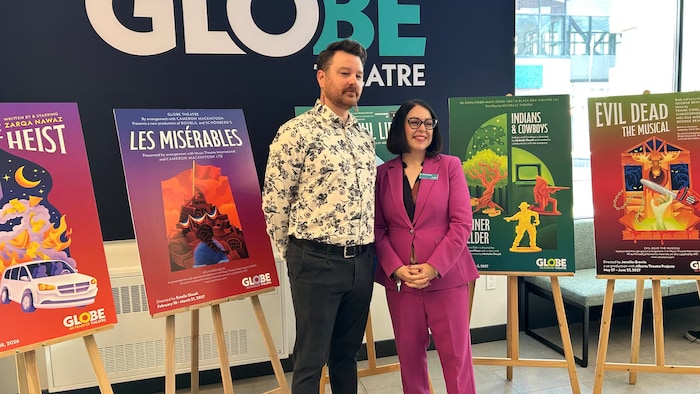 Oz Weaver, directeur général du Théâtre Globe, et Celina Philpot, PDG de Conexus Credit Union, posent devant les affiches des spectacles de cette saison.