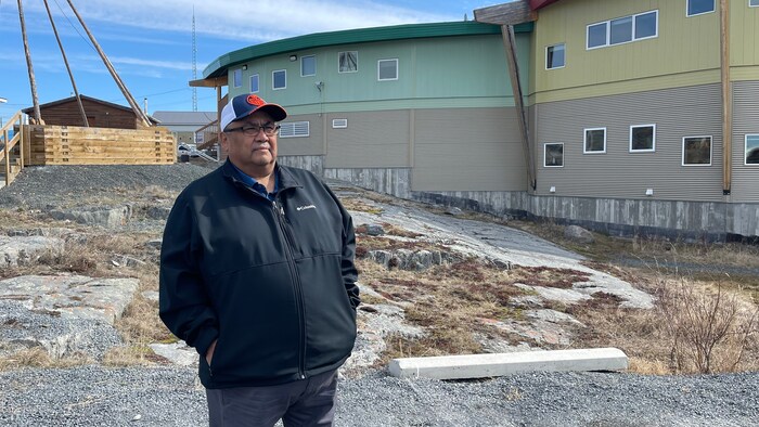 Edward Sangris, chef déné de Dettah, au sud-est de Yellowknife, aux Territoires du Nord-Ouest, pose devant des bâtiments à l'extérieur, en mai 2022.