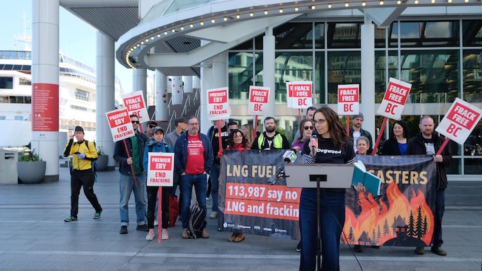 Un groupe de personnes brandit une banderole et des pancartes sur lesquelles on peut lire: Frack Free BC (libérez la Colombie-Britannique de la fracturation hydraulique).  