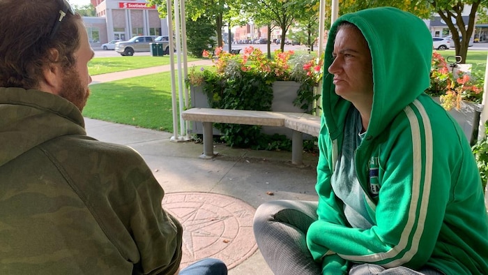 A man and a woman sitting in a park.
