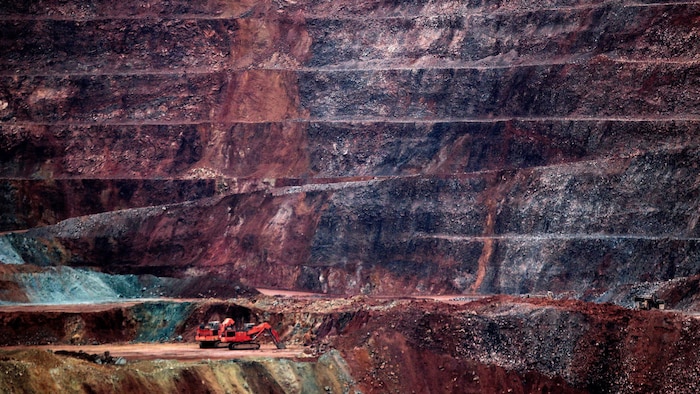 Une petite grue rouge tranche sur l'immensité de la mine.