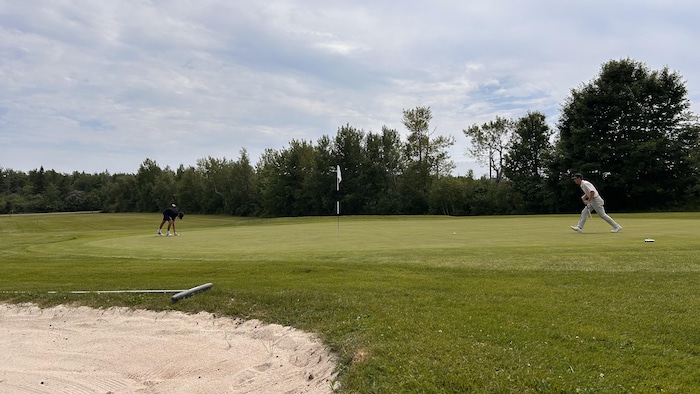 Deux personnes sur un terrain de golf.