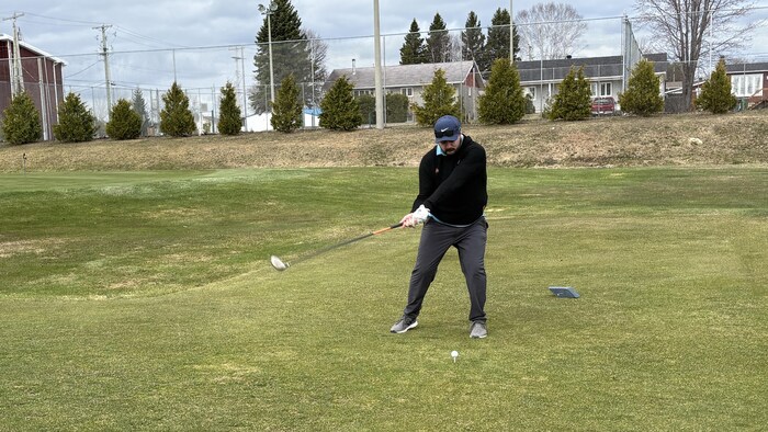 Un golfeur s'apprête à frapper une balle.