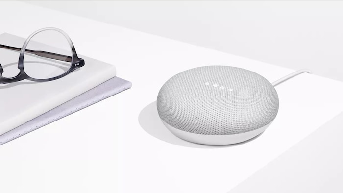 Une photo du Google Home Mini, un petit haut-parleur circulaire de la taille d'une rondelle de hockey.
