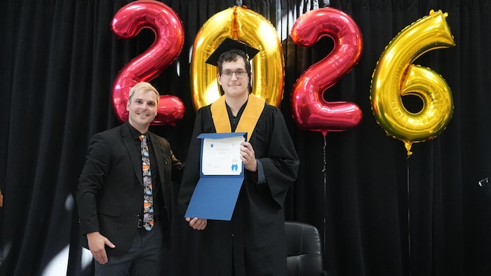 Pierre Cook et Timofei Zonov tenant son diplôme dans un habit de cérémonie.