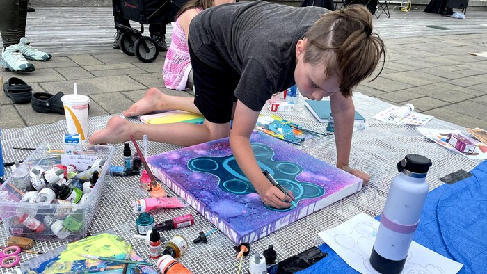 Un garçon peint un ourson coloré.