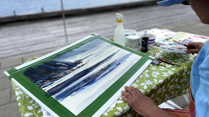 Une toile du bord de l'eau et de rochers.