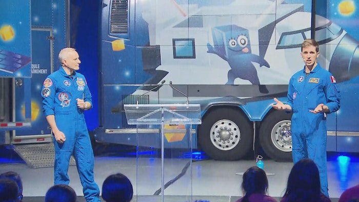 Deux astronautes devant un autobus.