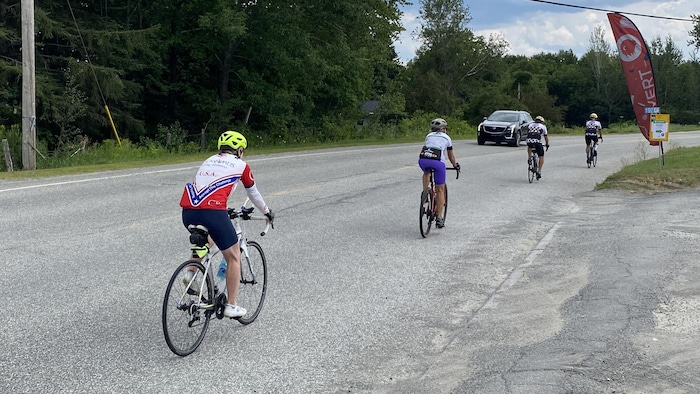 Des cyclistes pédalent en bordure de route.