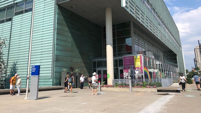 Des gens entrent dans l'édifice de la Grande Bibliothèque.