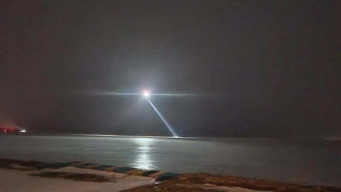 A helicopter in flight illuminates the bay. 