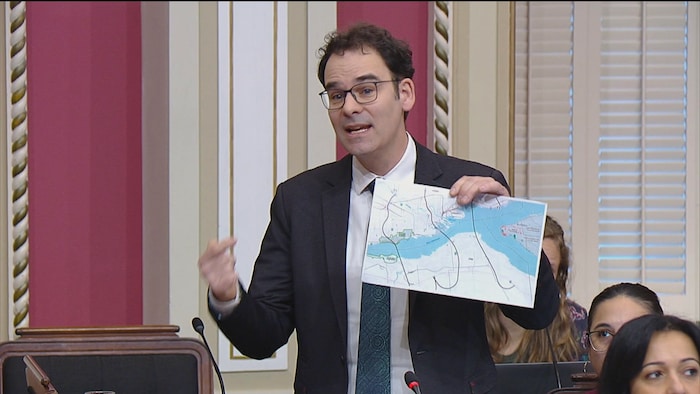 Le député montre une carte aux autres élus, lors d'une assemblée au Salon rouge.
