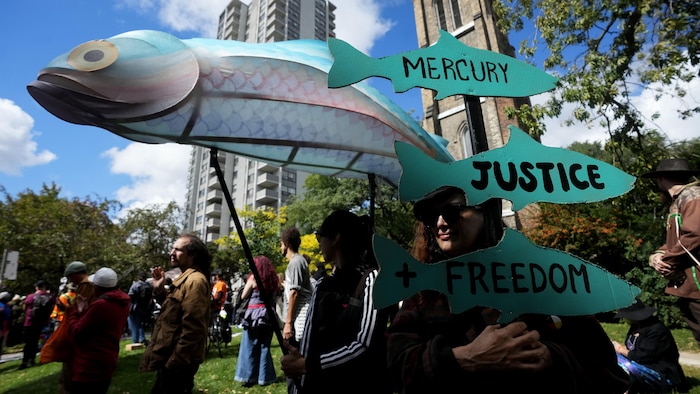 Des personnes manifestent pour réclamer justice concernant l'empoisonnement au mercure dans la Première Nation de Grassy Narrows, à Toronto, le mercredi 23 septembre 2026. 