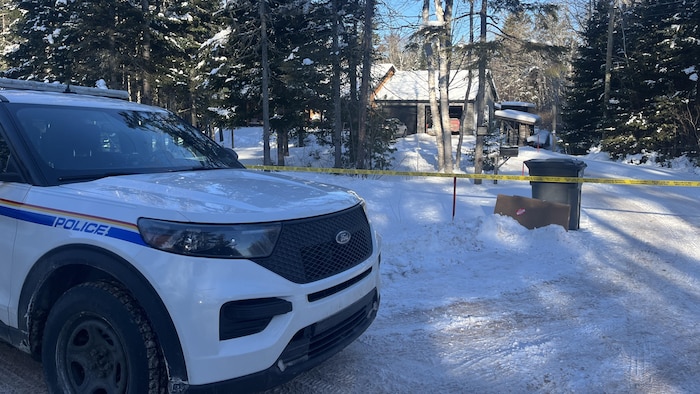 Une voiture de la GRC est garée devant une maison.
