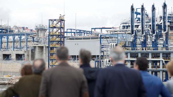 Des hommes observent des installations du terminal de GNL.