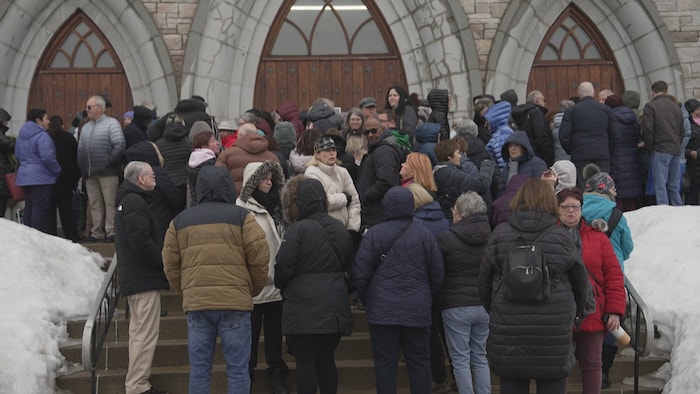 Des gens qui attendent devant l'église où aura lieu le spectacle.