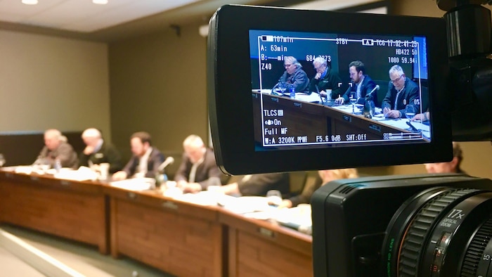 Photo prise de l'écran d'une caméra vidéo dans laquelle on voit le maire et des conseillers.