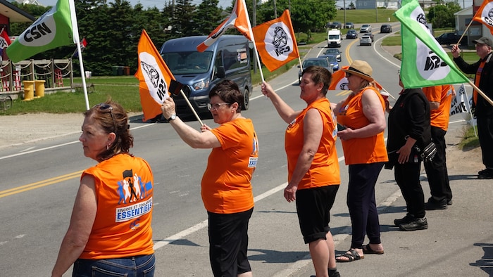 Des employés manifestent en bordure de la route 199.