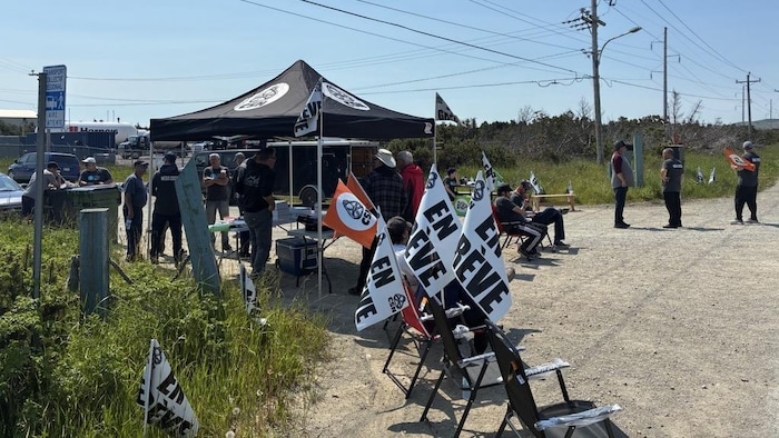 Des gens avec des pancartes aux couleurs de la CSN.