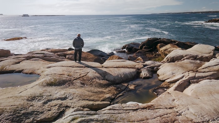Brian Muldoon est debout sur la grève.