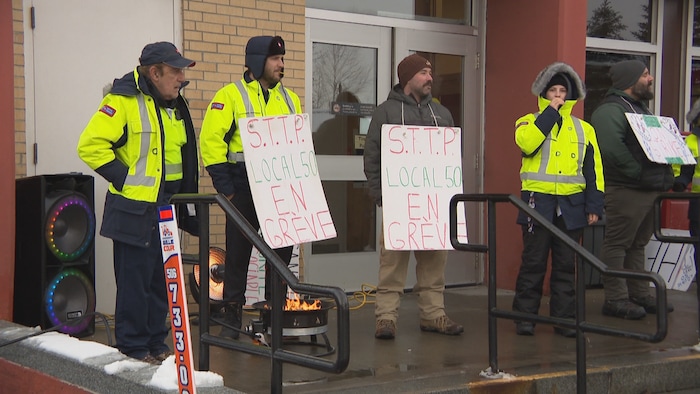 Des membres du syndicat manifestent devant un bureau de poste.