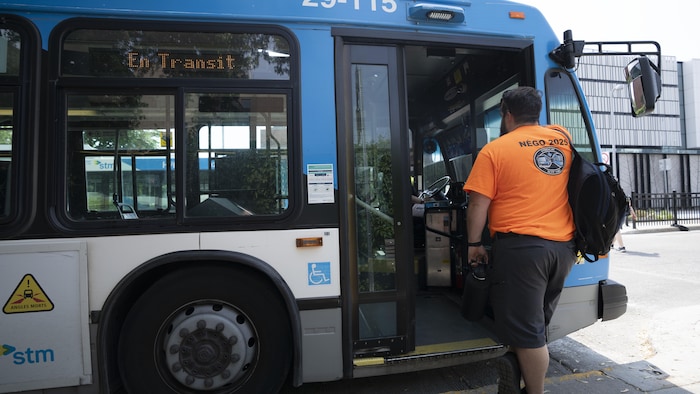 Un chauffeur d'autobus porte un chandail orange.