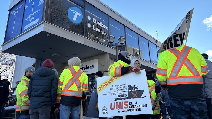 Un groupe d'employés avec des pancartes.