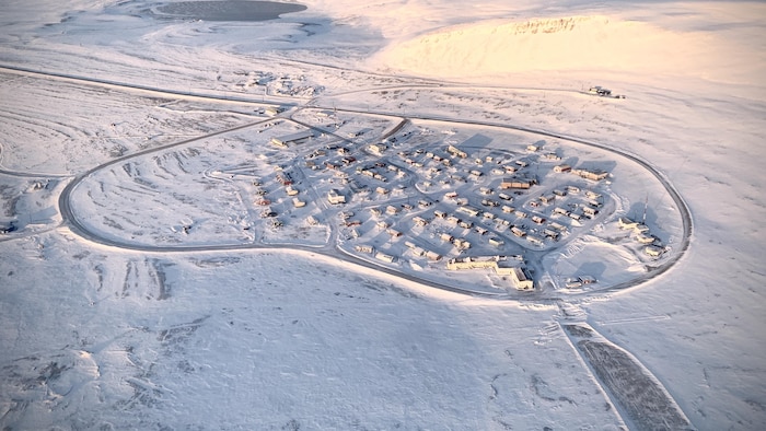Vue aérienne d'un village entourée de glace et de neige.