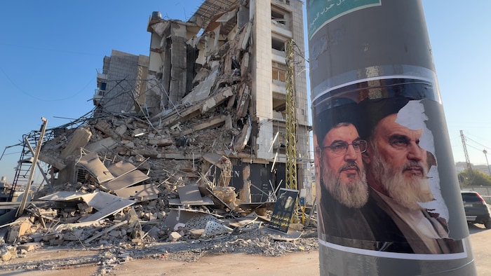 Photo d'un bâtiment en ruines, avec des portraits des deux derniers ayatollahs iraniens.