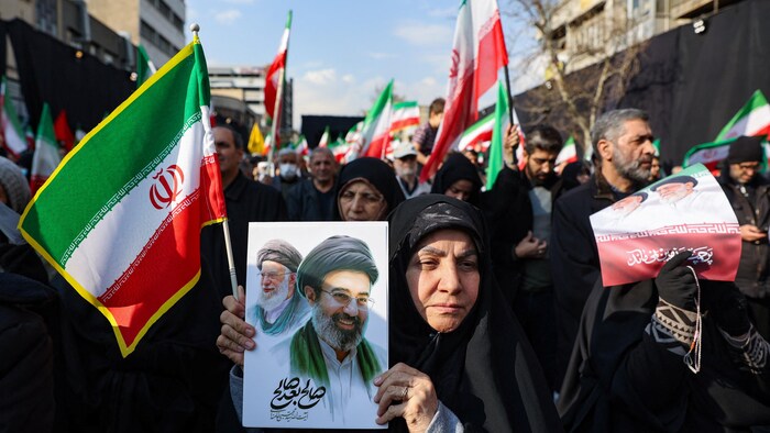 Une femme tient une photo du nouveau guide suprême iranien, Mojtaba Khamenei.