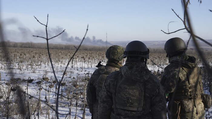 Des soldats ukrainiens regardent la fumée s'échapper de Soledar.