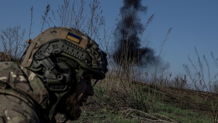 Un soldat avec en arrière-plan un nuage de fumée noire. 