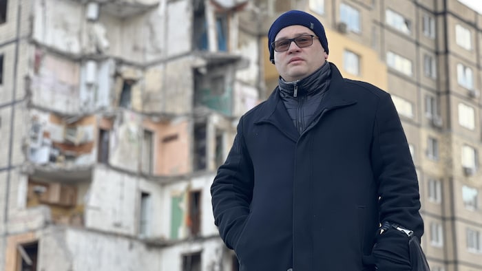 Eduard Usov devant l'immeuble en ruines, à Dnipro.