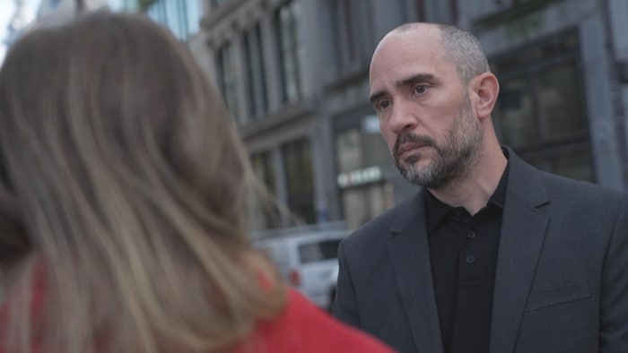 Un homme livre une entrevue sur le parvis de l'église Saint-Roch.