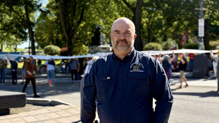 Un homme pose devant la caméra.