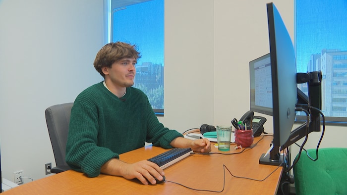 Guillaume Revillod travaille sur son ordinateur, dans un bureau vitré du centre-ville de Québec.