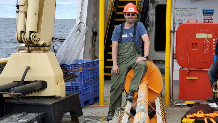 Une personne assise sur un instrument dans un bateau.