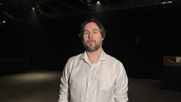 Un homme dans une salle de spectacle. 