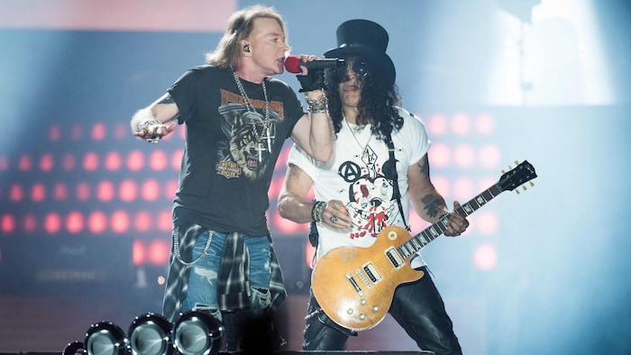 Le chanteur Axl Rose et le guitariste Slash côte à côte sur scène lors d'un concert. 