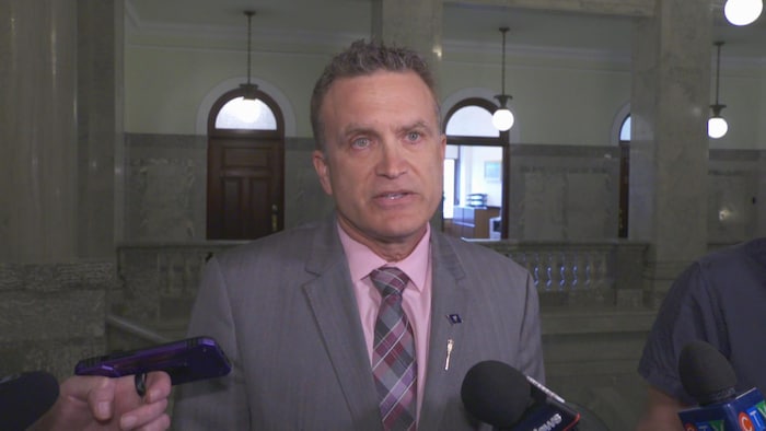 Le député provincial Peter Guthrie devant des journalistes.