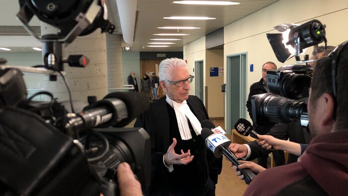 Me Guy Bertrand répond aux questions des journalistes lors d'une mêlée de presse dans les couloirs du palais de justice de Québec.