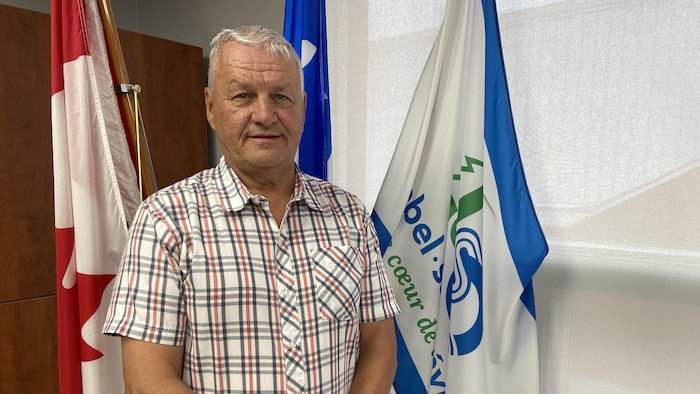 Guy Lafrenière près du drapeau de Lebel-sur-Quévillon.