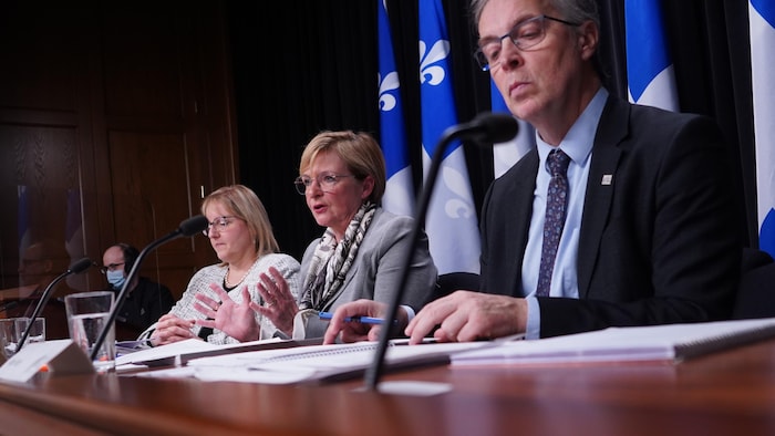 Trois personnes, dont Guylaine Leclerc, assises derrière des micros durant une conférence de presse.