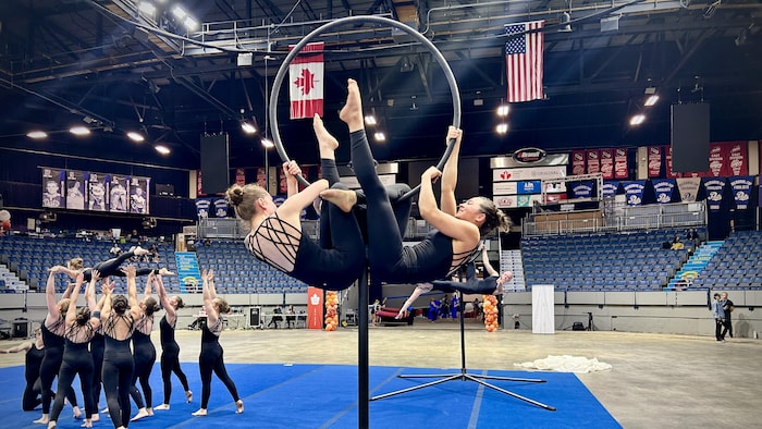 Deux gymnastes accrochées à un cerceau.