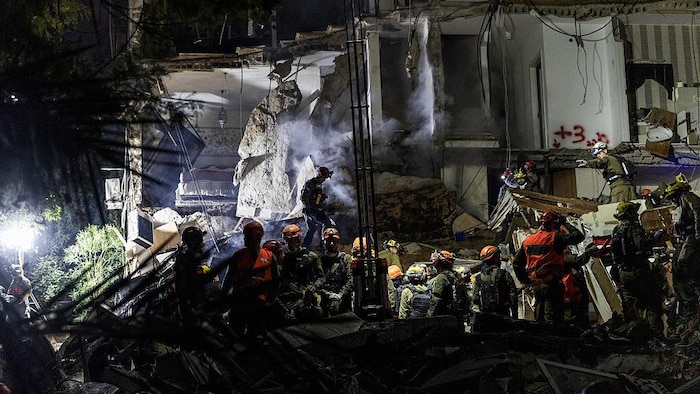 Des équipes israéliennes de recherche et de sauvetage interviennent sur le site d'un immeuble résidentiel détruit lors d'une frappe iranienne dans la ville de Haïfa, au nord du pays, le 5 avril 2026.