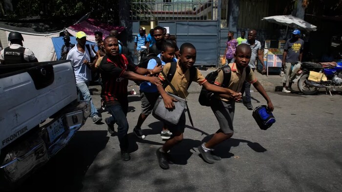 Children run towards their parents at the end of their school day as police carry out an operation against gangs in the Bel-Air area of Port-au-Prince, Haiti, on March 3. (Odelyn Joseph/Associated Press)